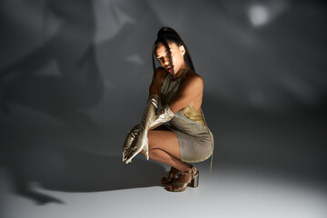 Chic young woman showcasing trendy attire and elegant style against artistic backdrop