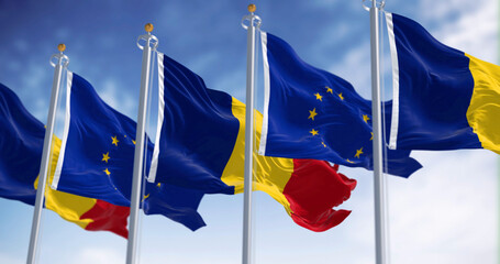 Romania and European Union flags waving in the wind on a clear day