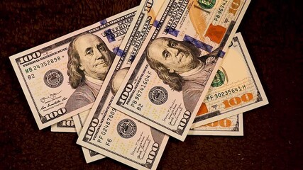 Falling $100 bills one by one, stacking on top of each other, totaling $5000. A visual representation of money accumulation, cash flow, and wealth building in a clean, professional setting.	
