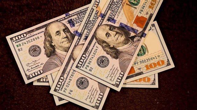 Falling $100 bills one by one, stacking on top of each other, totaling $5000. A visual representation of money accumulation, cash flow, and wealth building in a clean, professional setting.	
