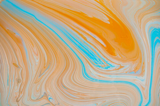 Swirling textures of orange and teal acrylic paint in abstract art