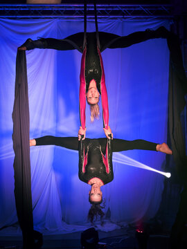 Trapeze artists acrobats performing stunning duo silk routine
