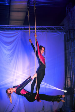 Graceful trapeze artists performance under vibrant stage lighting