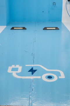 Electrical vehicle charging site with symbol on blue background