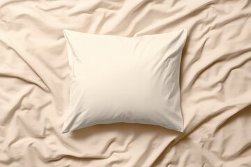Soft white pillow resting on a crumpled beige bedsheet, inviting comfort and relaxation in a cozy bedroom setting