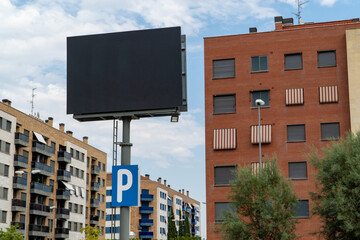 Large blank billboard in urban setting in Madrid with parking sign