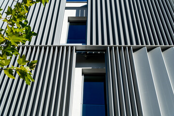 Modern building with metallic facade and greenery