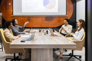 Collaborative office meeting with diverse team discussing presentation