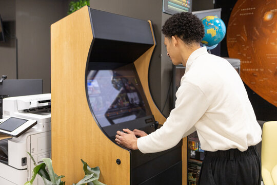Employee Enjoying Break with Office Arcade Gaming Station