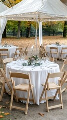 Obraz premium Beautiful outdoor wedding reception setup with elegant tables and nature backdrop featuring autumn foliage