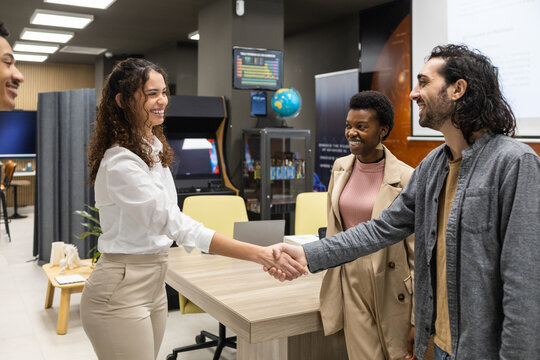 Welcoming Colleagues with a Handshake in a Modern Office