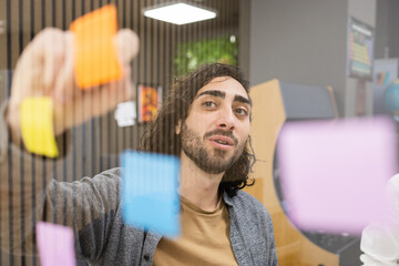 Team member organizing tasks with colorful sticky notes