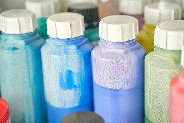 Colorful array of paint bottles in various shades of blue, green, and purple.