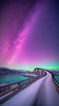 Stunning display of bifrost bridge under vibrant northern lights in arctic landscape