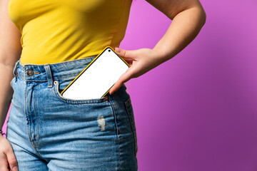 Woman putting smartphone with blank screen into jeans pocket