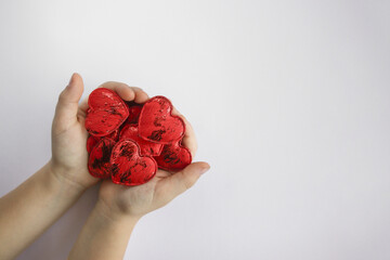 children's hands hold red hearts. love concept