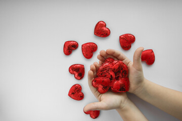 children's hands hold red hearts. love concept