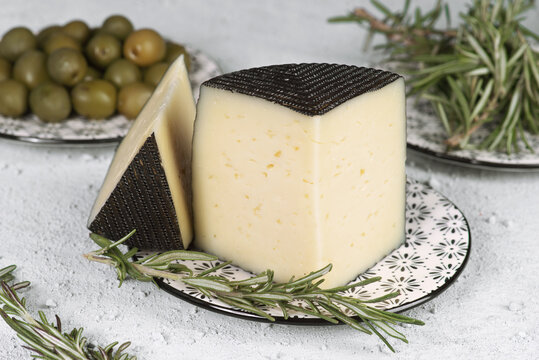 Delicious cheese with olives and rosemary on ceramic plate