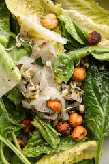 Crisp Greens with Sprouted Lentils, Toasted Hazelnuts, and Mustard Dressing in a Ceramic Bowl...