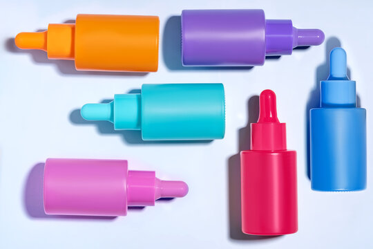 Assortment of colorful serum bottles on white background