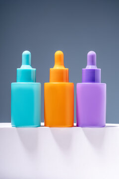 Colorful serum bottles on a gray gradient background
