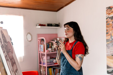 Young Female Artist Holding a Vintage Camera in Her Studio