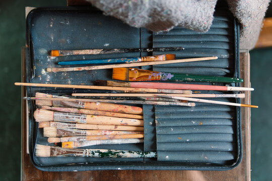 Collection of Used Paintbrushes in a Fabric Case on Artist’s Table