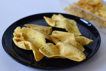 Fafda served on a black plate. A popular Indian snack from Gujarat