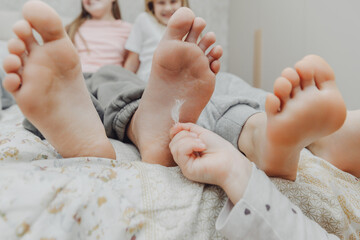 children tickle each other's heels with a feather