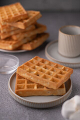 photo Deliciously Golden Waffles on Ceramic Plates for Breakfast or Brunch Time Featuring Crispy Texture and Perfectly Baked Batter, Ideal for Sweet or Savory Toppings