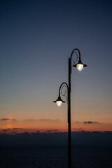 Public street lighting pole with LED lights with sunset color background.