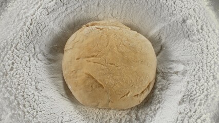 Freeze Motion of Falling Yeast Dough into Flour . Closeup of Bread or Pizza Dough Preparation