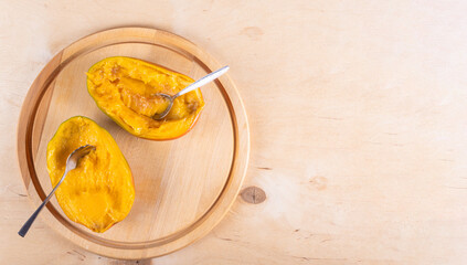 Two halves of mango on light beige wooden background with negative space