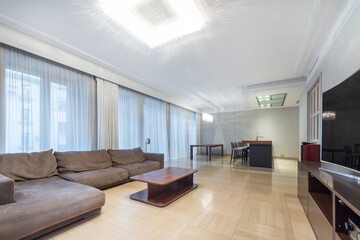 Apartments with modern interior design. Bright room decor, parquet floor. Panoramic .Windows with beautiful curtains, stylish furniture.