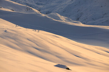 Tranquil Snow-Covered Terrain at Golden Hour with ski tracks in the background. Les Menuires. French Alps.  France