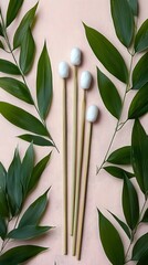 Pair of chopsticks with green leaf and delicate bamboo cotton swabs on a neutral background