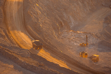 Industry work of trucks and excavator in open pit on gold mining, drilling machine.