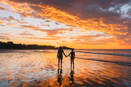 Couple walking on the beach at sunset in Costa Rica