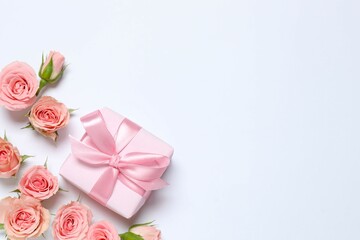 Beautiful composition with gift box and pink roses on white background