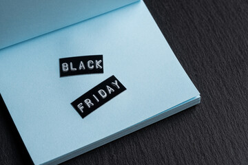 Black friday label on blue envelope on black background with copy space.