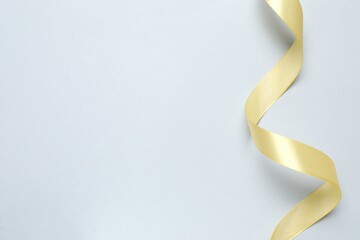 Beautiful golden silk ribbon on gray background