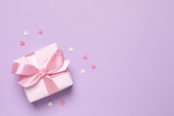 Beautiful composition with gift box and pink hearts on color background