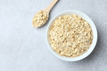 Composition with oatmeal flakes on gray background. Cooking breakfast