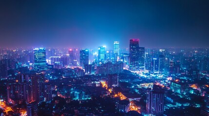 Fototapeta premium A city at night, glowing with bright neon lights against a dark blue sky.