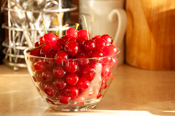 Red ripe cherries in glass bowl on a table