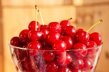 Red ripe cherries in glass bowl on a table