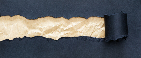 Crumpled brown paper strip under black paper with curled edges creating a contrast for text.