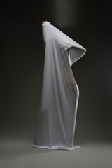 Sensual woman playfully draped in sheer fabric in a dimly lit space