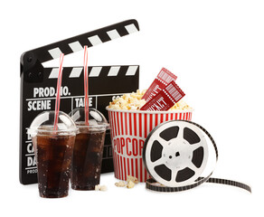 Tasty popcorn, film reel, clapper, soda drinks and movie tickets isolated on white