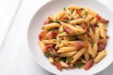 Mezze penne con guanciale croccante e asparagi selvatici, pasta italiana, gastronomia europea 
